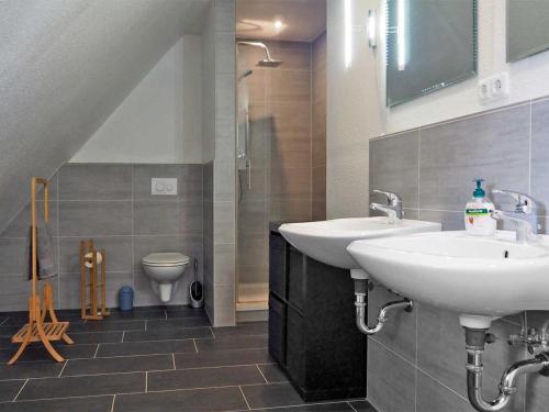 a bathroom with two sinks and a toilet at Familie Horn - Urlaub im Reetdachhaus in Schleswig-Holstein in Silberstedt