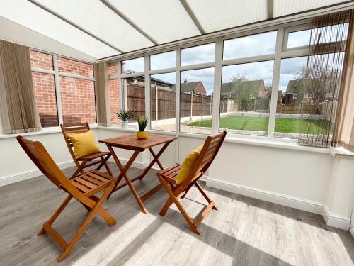 a conservatory with two chairs and a table in front of a window at Worksop Newly Refurbished 3-Bedroom House in Worksop