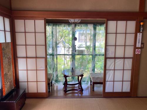 a room with a glass door with a table in it at 宮城野ハウス＆離れ in Gora
