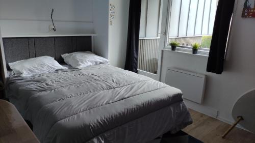 a bedroom with a bed in a room with a window at Studio avec balcon et vue sur le Sancy in Le Mont-Dore