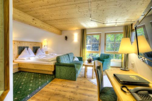 a hotel room with a bed and a desk at Hotel Häuserl im Wald in Mariapfarr