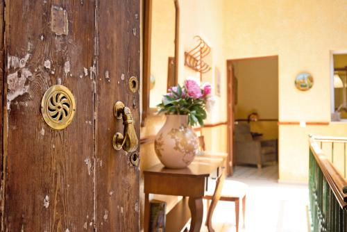 una puerta de madera con un jarrón con flores sobre una mesa en Casa Pepa, en Chiclana de la Frontera