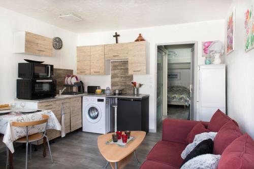 un salon avec un canapé rouge et une cuisine dans l'établissement Appartement Royan Rayley, à Royan