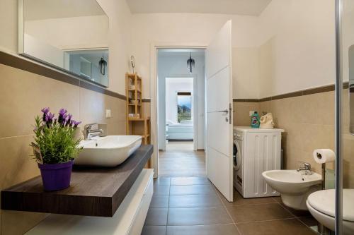 a bathroom with two sinks and two toilets at Residence La Villa Fewo Cristallo in Tignale