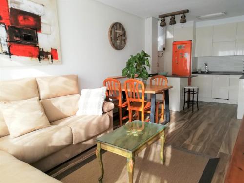 een woonkamer met een bank en een tafel bij Apartamento a 30 metros de la playa in San Vicente de la Barquera