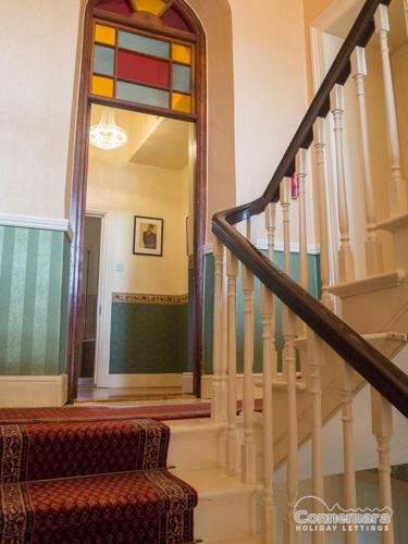 a hallway with a staircase with a stained glass window at Kill House, Kingstown in Clifden