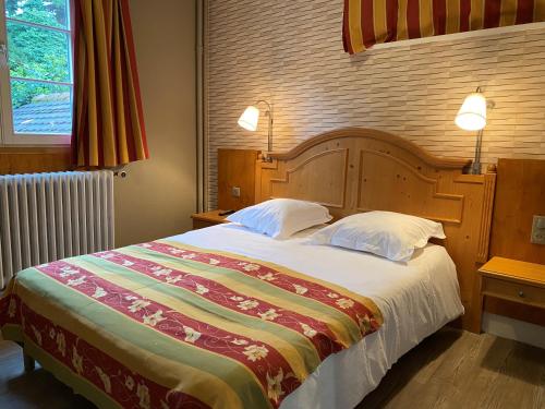 Llit o llits en una habitació de Hotel Au Cerf
