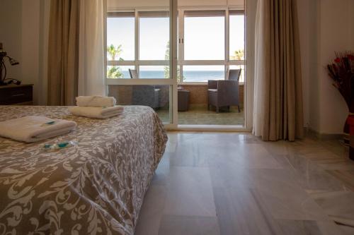 a bedroom with a bed and a view of the ocean at Gold Mencía in Torrox Costa