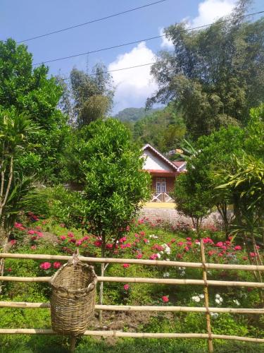 a basket on a fence in a garden with flowers at Odyssey Stays Rimbi in Pelling