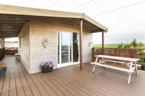 a wooden deck with a bench and a shed at The Viewpoint in Deal
