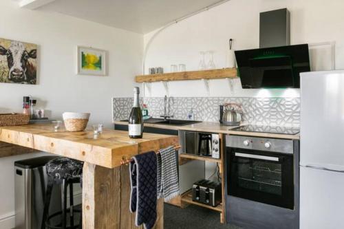 a kitchen with a wooden counter top and a refrigerator at The Viewpoint in Deal