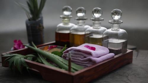 a wooden tray with three bottles of oils and towels at Brij Lakshmansagar, Pali - Small Luxury Hotels of the World in Raipur