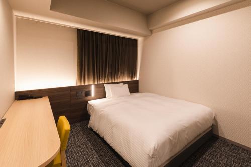 a hotel room with a bed and a table and a window at SOTETSU GRAND FRESA TAKADANOBABA in Tokyo