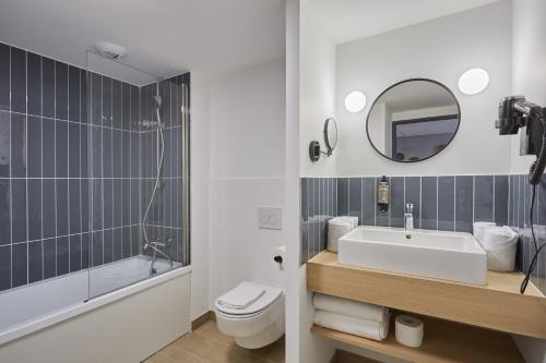 布拉尼亚克Appart Hotel Odalys City Toulouse Blagnac Aéroport的带水槽、马桶和镜子的浴室