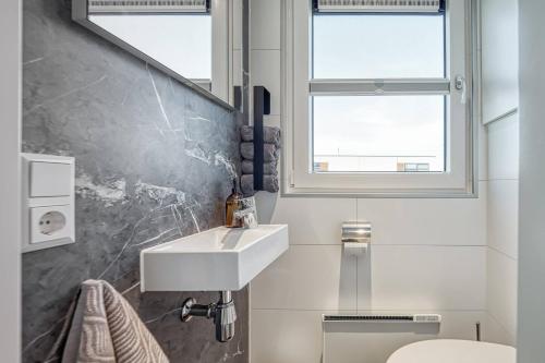 La salle de bains est pourvue d'un lavabo, de toilettes et d'une fenêtre. dans l'établissement Floatinghouses BernsteinResort, à Ribnitz-Damgarten