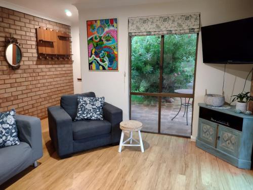 a living room with a couch and a chair at Chuditch Holiday Home Dwellingup - Great Central Location in Dwellingup