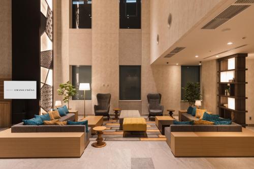 a lobby with couches and chairs in a building at SOTETSU GRAND FRESA TAKADANOBABA in Tokyo