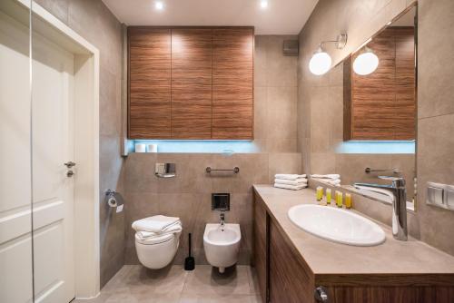 a bathroom with a white toilet and a sink at City Centre Luxury Apartment by BookingHost in Warsaw