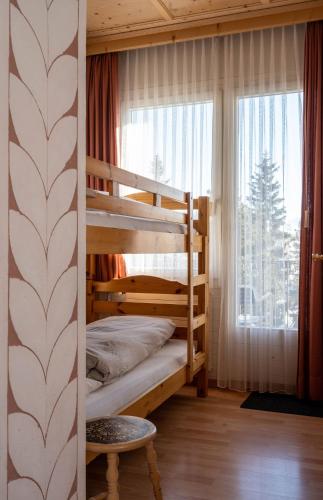 a bedroom with two bunk beds and a window at Hotel Bären in St. Moritz