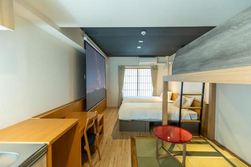 大阪市にあるMinn 新大阪のベッドとデスクが備わる小さな客室です。