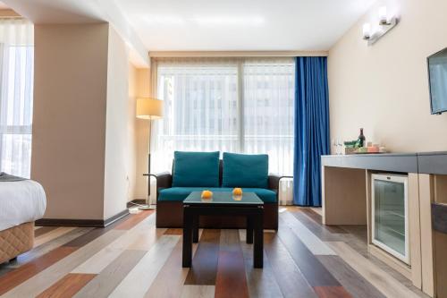 a living room with a blue couch and a table at Lazz By Ketenci Hotel in Izmir