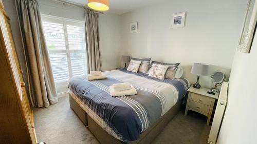 1 dormitorio con 1 cama con 2 toallas en JC's Cabin - Bijou and charming with parking onsite en Dartmouth