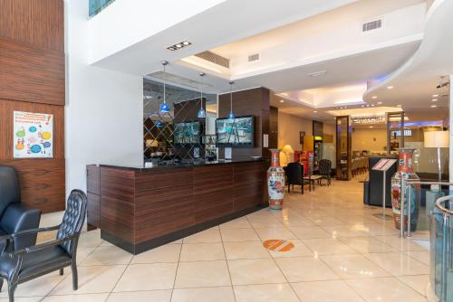 a restaurant lobby with a bar and chairs at Lazz By Ketenci Hotel in Izmir