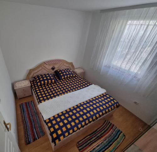 2 camas individuales en una habitación con ventana en Apartman MiG, en Berkovac