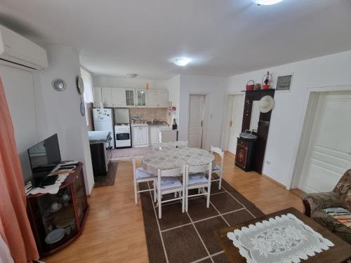 cocina y sala de estar con mesa y sillas en Apartman MiG en Berkovac