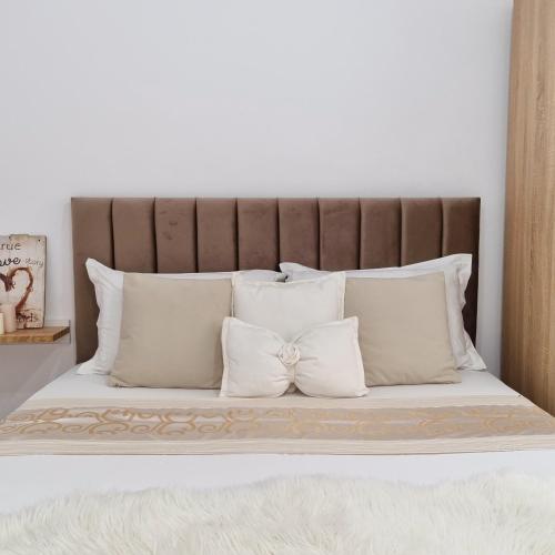 a bed with white pillows and a brown headboard at Green Villa in Vlorë