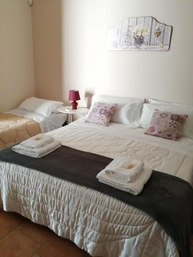 a bedroom with a large bed with towels on it at Villa Etna Masi' in Milo