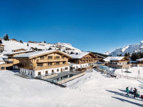 a group of people standing in the snow in front of a building at Burg Vital Resort in Lech am Arlberg