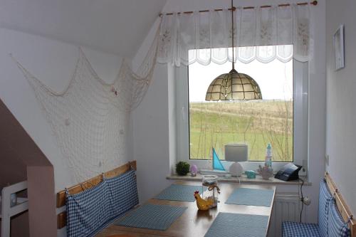 Zimmer mit einem Tisch und einem großen Fenster in der Unterkunft Ferienhof am Watt in Tönning