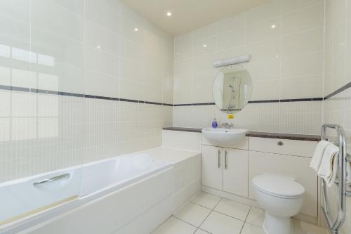 a white bathroom with a toilet and a sink at Melfort Village in Oban