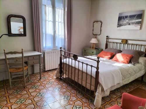 Saint-André-de-Sangonis的住宿－魯塞爾公寓，一间卧室配有一张床、一张书桌和一面镜子