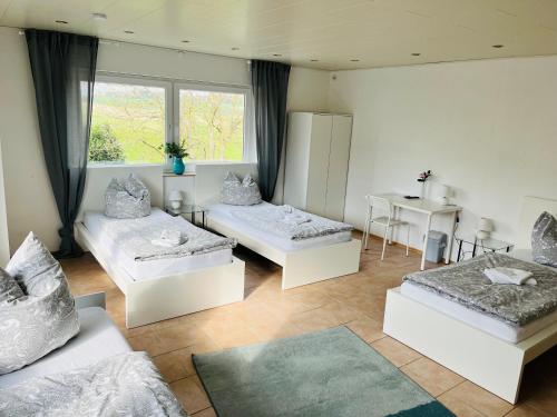 uma sala de estar com três camas e uma mesa em Pension Platzhirsch em Mücke