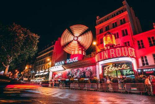 a building with a ferris wheel on top of it at Le Village Montmartre by Hiphophostels in Paris