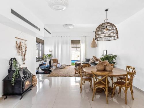 a living room with a table and a fireplace at Perfect Villa in Beer Sheva