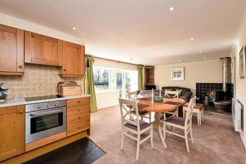 a kitchen and dining room with a table and chairs at Melfort Village in Oban