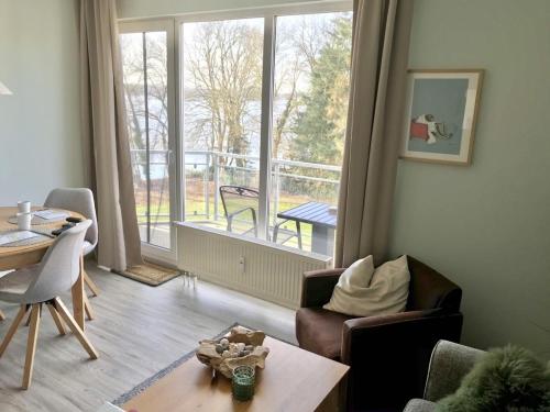 sala de estar con vistas a un balcón en FeWo SaMa, Balkon zum Plöner See, en Ascheberg