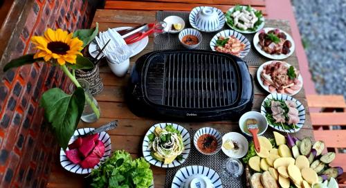 a table with a grill and plates of food at La Beauté Sa Pa in Sa Pa