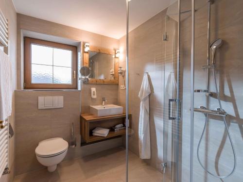 a bathroom with a shower and a toilet and a sink at SCOL Sporthotel Zillertal in Fügen