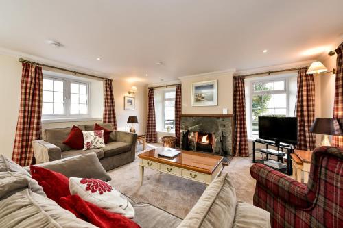 a living room with a couch and a fireplace at Melfort Village in Oban
