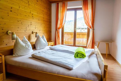 a bed in a room with a large window at Appartement Höllwarthof in Goldegg