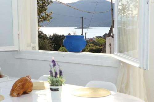 un gato sentado en una mesa frente a una ventana en White Villa in Olive trees and Seaview to Panagia, en Almiropótamos