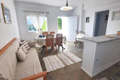 a living room with a couch and a table at White Villa in Olive trees and Seaview to Panagia in Almiropótamos