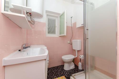 a pink bathroom with a sink and a toilet at Apartment Anka in Orebić