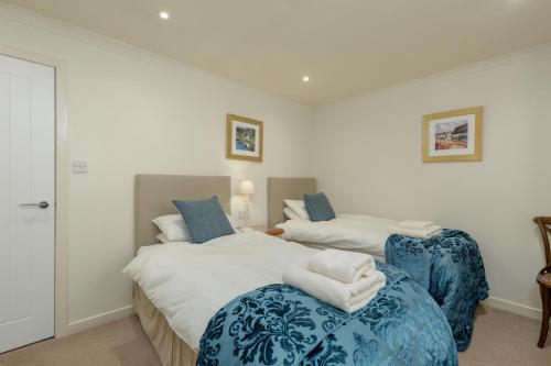 a bedroom with two beds with blue and white sheets at Melfort Village in Oban