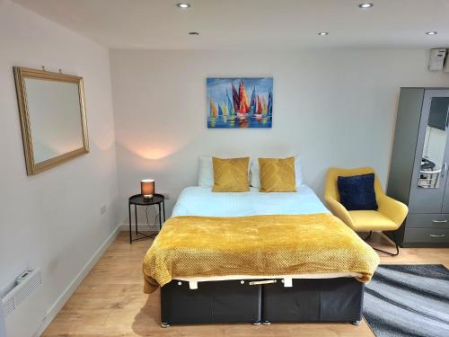 a bedroom with a bed and a yellow blanket at Lovely central studio/2bed - 5min to train station in Slough