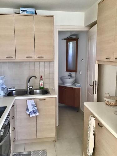 a kitchen with wooden cabinets and a sink and a sink at Sea Breeze - Home with a View in Bouzéïka